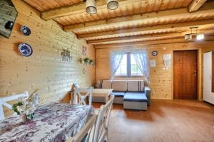 Habitación con cama y sofá en una habitación en Domki całoroczne DOMKOWSTWO en Bóbrka