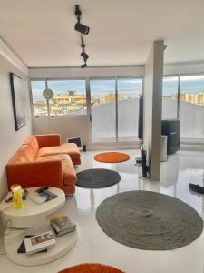 a living room with a couch and tables and windows at 14eme et dernier étage - 3 pieces "Arty" de 65 m2 avec vue panoramique ! in Créteil
