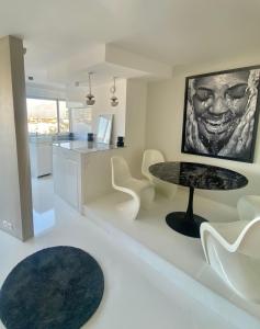 a living room with a table and white chairs at 14eme et dernier étage - 3 pieces "Arty" de 65 m2 avec vue panoramique ! in Créteil