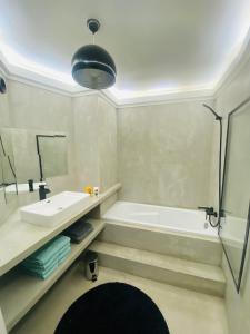 a bathroom with a tub and a sink and a shower at 14eme et dernier étage - 3 pieces "Arty" de 65 m2 avec vue panoramique ! in Créteil