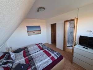 una camera da letto con un letto e una TV a schermo piatto di Pension Gästehaus Elfriede Baltrum a Baltrum