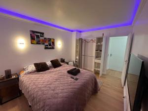 - une chambre avec un grand lit et un plafond violet dans l'établissement * NEW STYLE proche de la gare *, au Mans