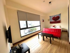 花蓮市的住宿－二街窩窩電梯民宿花蓮車站東出口Second street Nest Hostal，客厅设有红色的沙发和窗户。