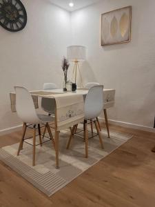 a dining room table with white chairs and a lamp at * NEW STYLE proche de la gare * in Le Mans