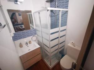 a bathroom with a shower and a toilet and a sink at Atlantis Surf Hostel in Moya
