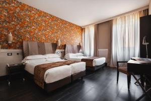 una camera d'albergo con due letti e un pianoforte di Unica Suites Rome a Roma