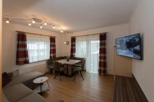 a living room with a couch and a table at Gästehaus Ingeborg in Saalbach Hinterglemm