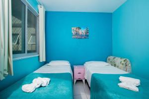two beds in a room with blue walls at Apartamento Frente Piscina Térreo no Palm Village em Porto de Galinhas - Eco11 in Porto De Galinhas +42 photos