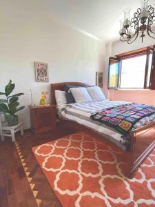 a bedroom with a large bed with a red rug at Pilgrim Stop Over - Tomar Village 