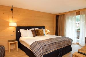 a bedroom with a large bed with wooden walls at Matterhorn Lodge Hotel & Appartements in Zermatt