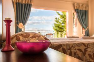 a pink bowl on a table with a lamp and a bed at Thalassa Hotel in Paleros