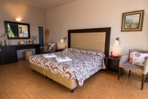 Habitación de hotel con cama y silla en Thalassa Hotel, en Paleros