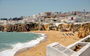a view of a beach with people and buildings at Aquamar Albufeira Aparthotel in Albufeira