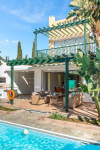 een villa met een zwembad en een huis bij Villa Poseidon Gardens by Ezoria Villas in Larnaka