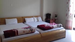 twee bedden naast elkaar in een slaapkamer bij Tic Guest House in Liên Trì (3)