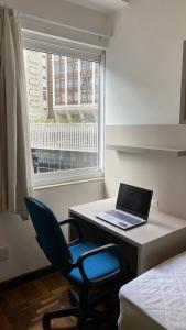 a room with a desk with a laptop computer on it at POSIT APARTAMENTOS in Curitiba