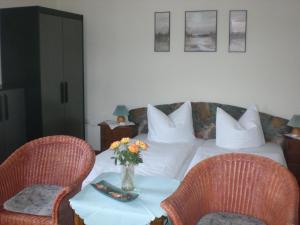 a bedroom with a bed with a table and two chairs at Pension Villa Sophia in Sassnitz