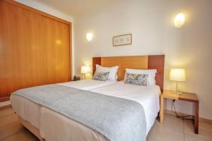 a bedroom with a large bed and two lamps at Aquamar Albufeira Aparthotel in Albufeira