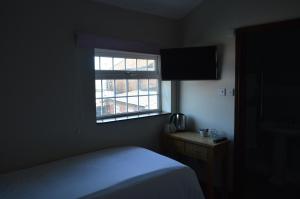 a bedroom with a bed and a window at The Ilchester Arms Hotel in Ilchester