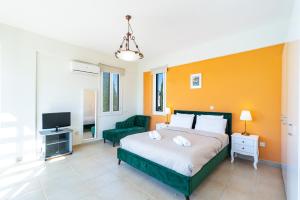 Villa Poseidon Gardens by Ezoria Villas في لارنكا: غرفة نوم فيها سرير وتلفزيون