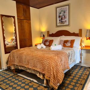 1 dormitorio con 1 cama con toallas en Pousada Lago Azul, en Monte Verde