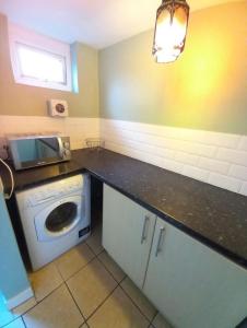 a kitchen with a washing machine and a microwave at 2 Well St in Llanberis
