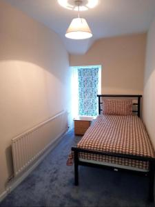 a bedroom with a bed and a window at 2 Well St in Llanberis