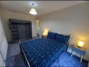 a bedroom with a blue bed with a blue comforter at 2 Well St in Llanberis