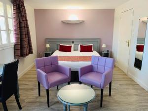 een slaapkamer met een bed en 2 paarse stoelen bij Logis Hôtel Le Moulin de la Coudre in Venoy