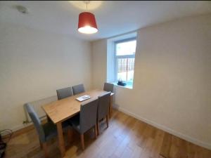 a dining room with a table and chairs and a window at 2 Well St in Llanberis