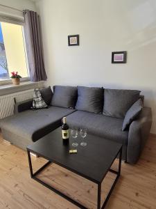 a living room with a couch and two wine glasses at Ferienwohnung Schlafende Hexe in Bad Reichenhall