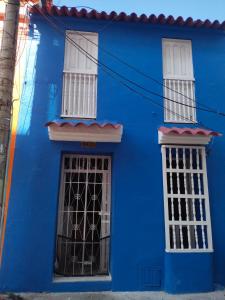 um edifício azul com janelas brancas em Casa 39-37 em Cartagena das Índias