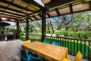 Une table et des chaises en bois sont disponibles sur la terrasse. dans l'établissement Luxury Vacation Rentals At Hacienda Pinilla, à Tamarindo