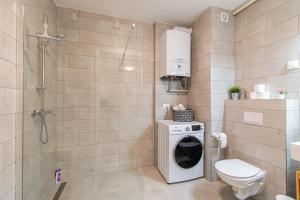 uma casa de banho com uma máquina de lavar roupa e um chuveiro em Flexible SelfCheckIns 39 - Zagreb - Parking - New em Zagreb