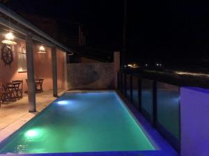 einen Pool in der Nacht mit Lichtern auf der Terrasse in der Unterkunft B&B Beach House Pousada Exclusiva pés na água Pontal do Peba única em Alagoas in Pontal do Peba