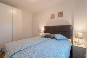 1 dormitorio con 1 cama grande con manta azul en Flexible SelfCheckIns 39 - Zagreb - Parking - New en Zagreb
