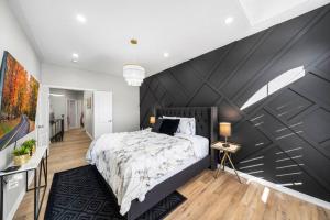 a bedroom with a large black accent wall at Modern 4 Level home-Game room/Parking/Near Airport in Mississauga