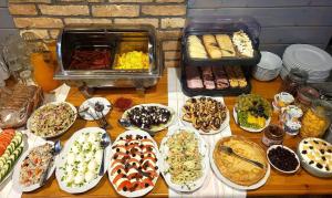 a table topped with lots of different types of food at Folwark Hutta in Suwałki