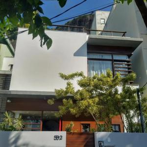 una casa bianca con degli alberi di fronte di Luna Rossa Guest House a Rio de Janeiro