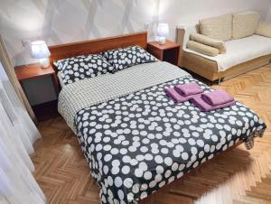 a bedroom with a black and white bed and a chair at Bright and cozy apartments in the center in Vinnytsya