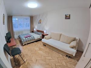 sala de estar con sofá y cama en Bright and cozy apartments in the center, en Vínnytsia