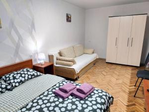 a small bedroom with a bed and a couch at Bright and cozy apartments in the center in Vinnytsya