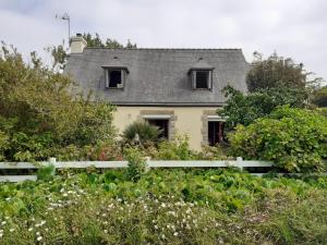 ein Haus mit einem weißen Zaun vor einem Garten in der Unterkunft Chez Kat Location Ile de Groix in Groix