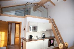 a kitchen with white cabinets and a ladder above a sink at Filzenhof in Kitzbühel