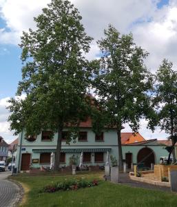 un edificio con dos árboles delante de él en Auberge SYRA/ Proche Europa Park, en Marckolsheim