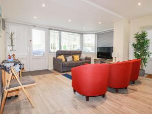un soggiorno con sedie rosse e un divano di Falcon House a Tintagel