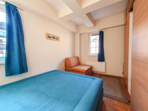 - une chambre avec un lit bleu et une chaise dans l'établissement Apartman Cvejic - Suncani apartmani, à Brzeće