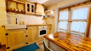 a kitchen with a wooden table and a sink at Amorino Cres - Old Town House in Cres