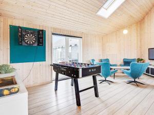 Seven-Bedroom Holiday home in Sydals في Høruphav: غرفة مع طاولة بينج بونغ وكراسي زرقاء