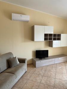 a living room with a couch and a tv at Appartamenti Estivi in Cirò Marina
